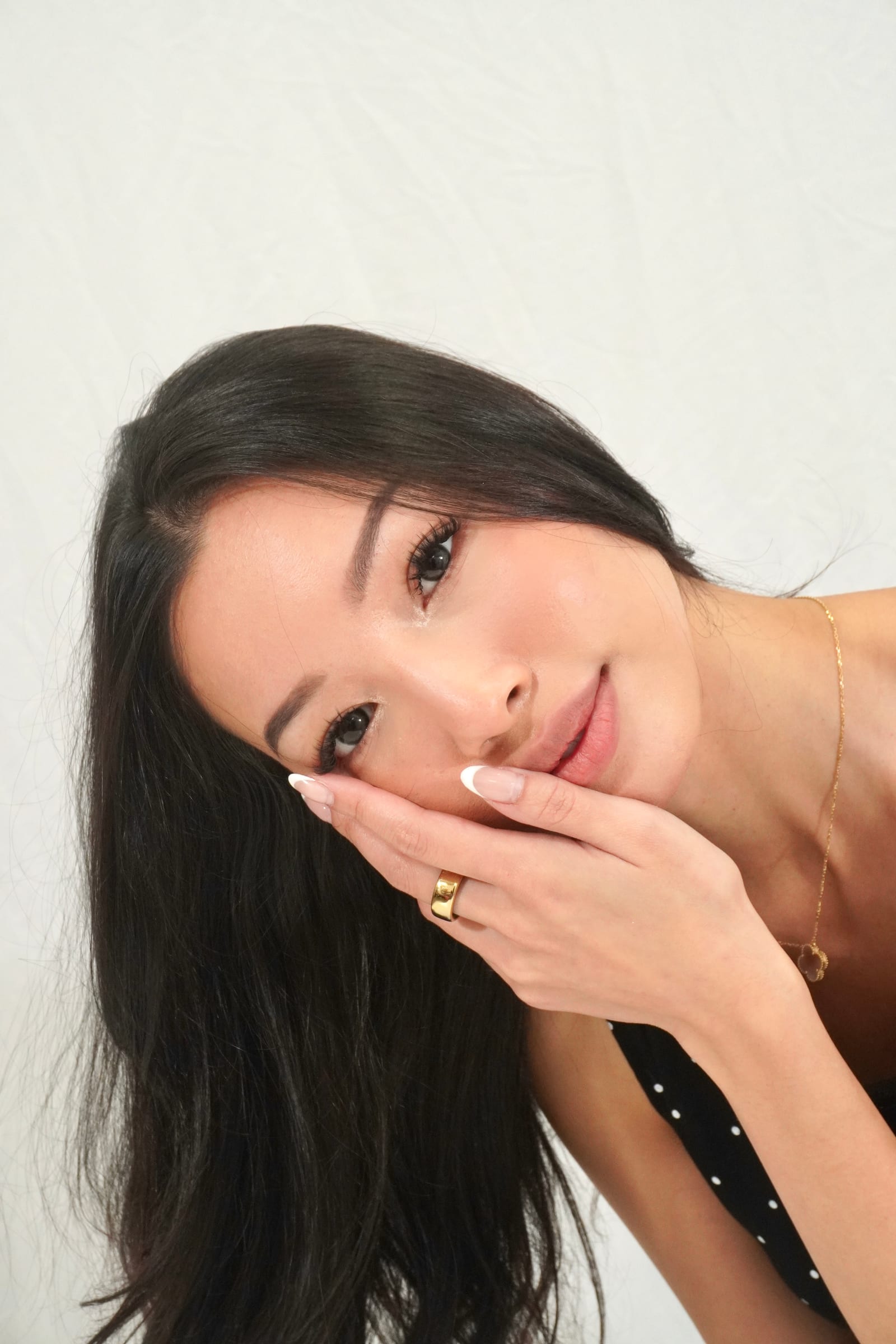 Woman reclining with one hand at her cheek and her lashes in focus.