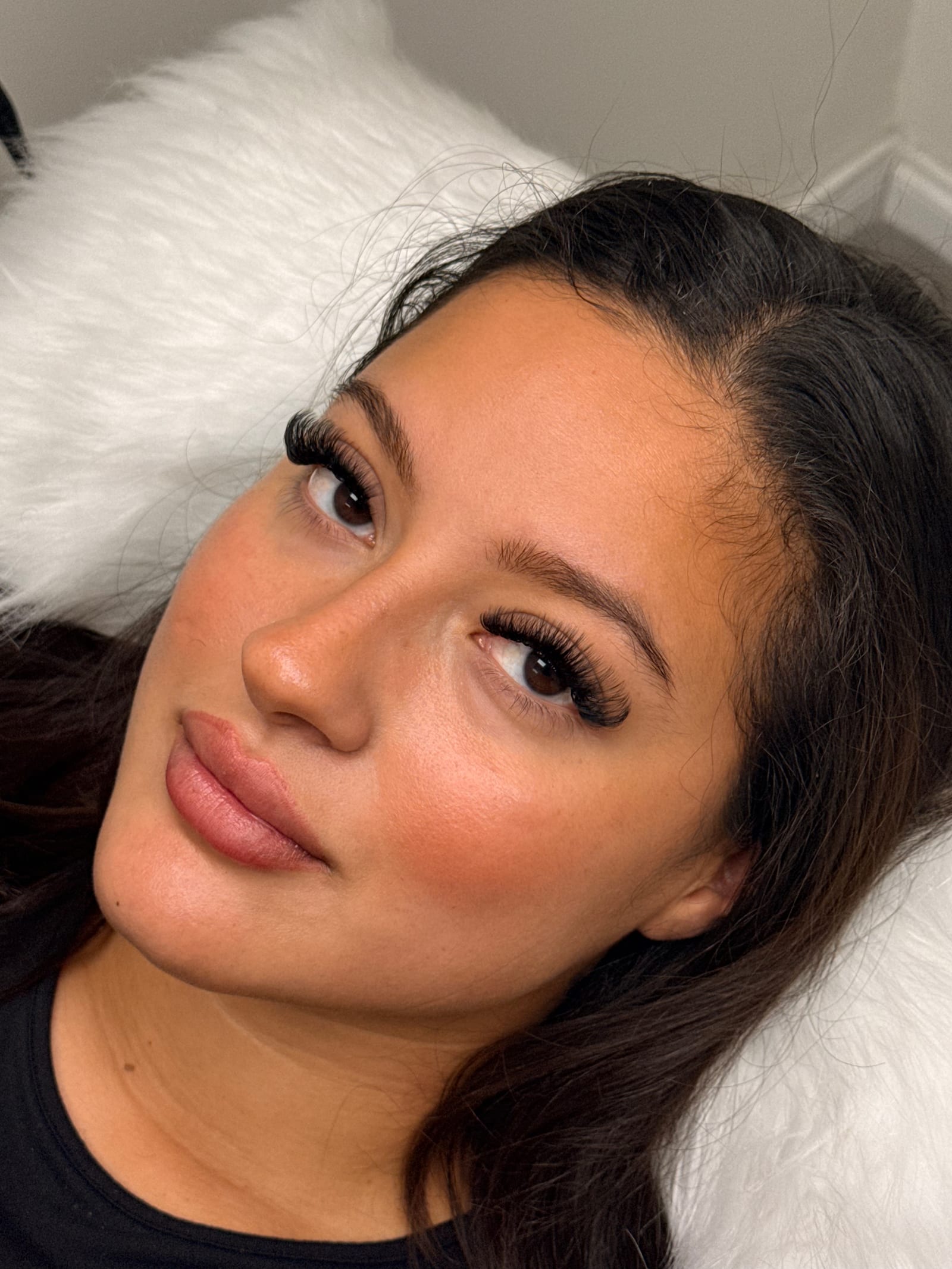 Reclining close-up highlighting a full lash look.