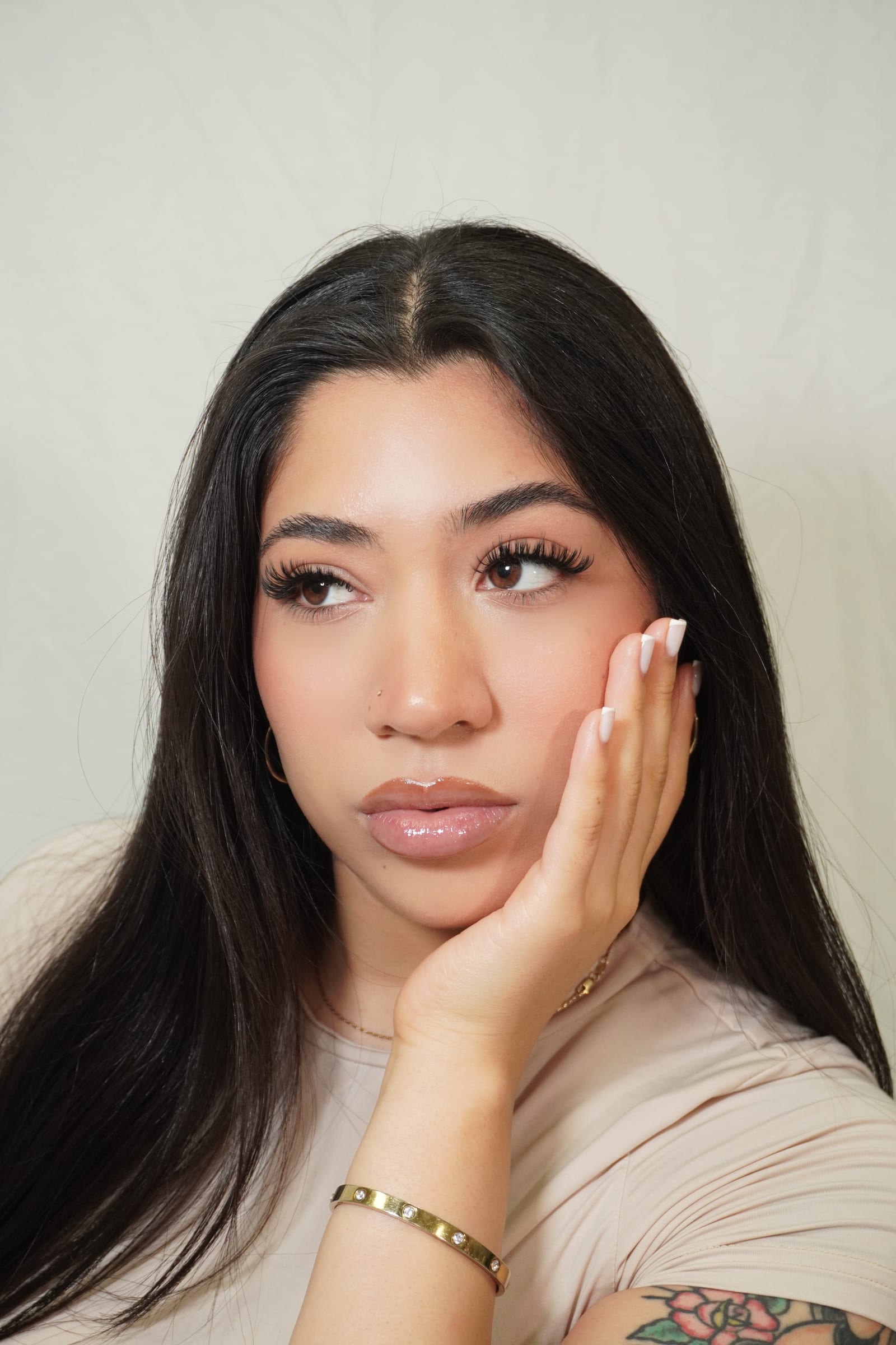 Woman resting her cheek in her hand with her lashes in focus.
